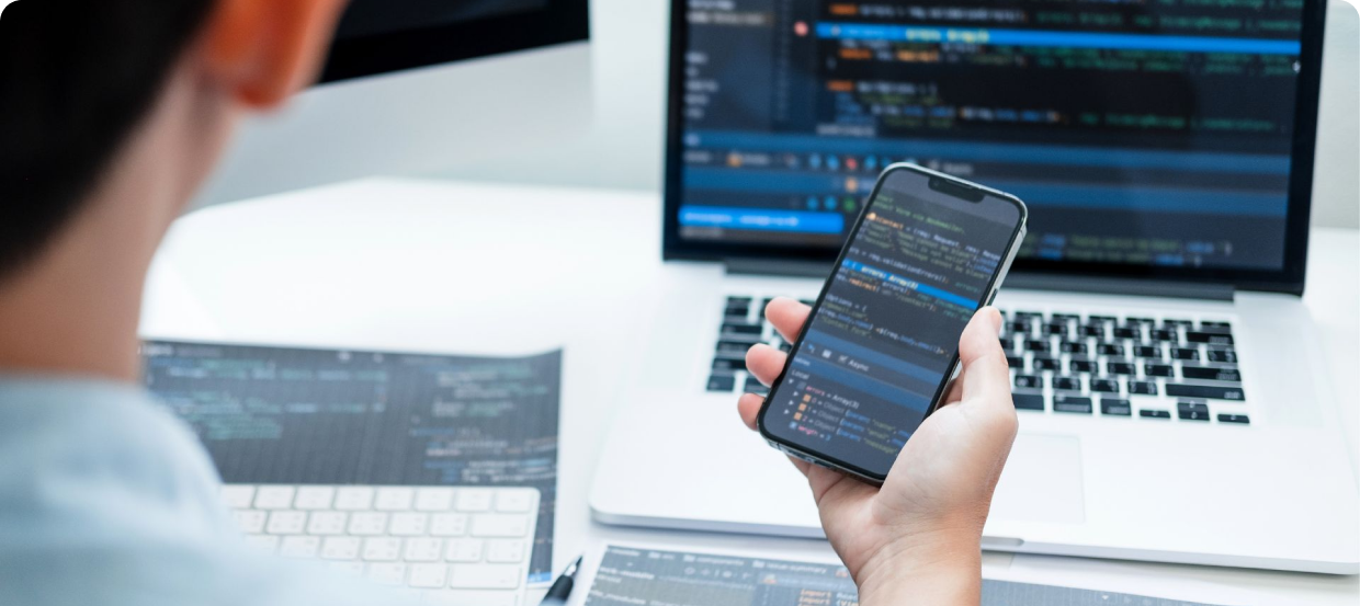 a man hand grabbing a phone while developing mobile app