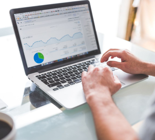 a man hand above the laptop while checking the website analytic